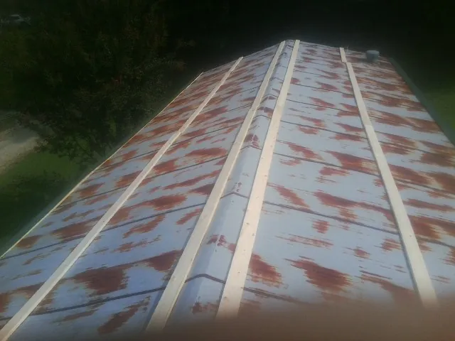 Rusted metal roof panels with new wood purlins before replacement — Storm Damage Roof Repair in Gassaway by Roofing Brothers