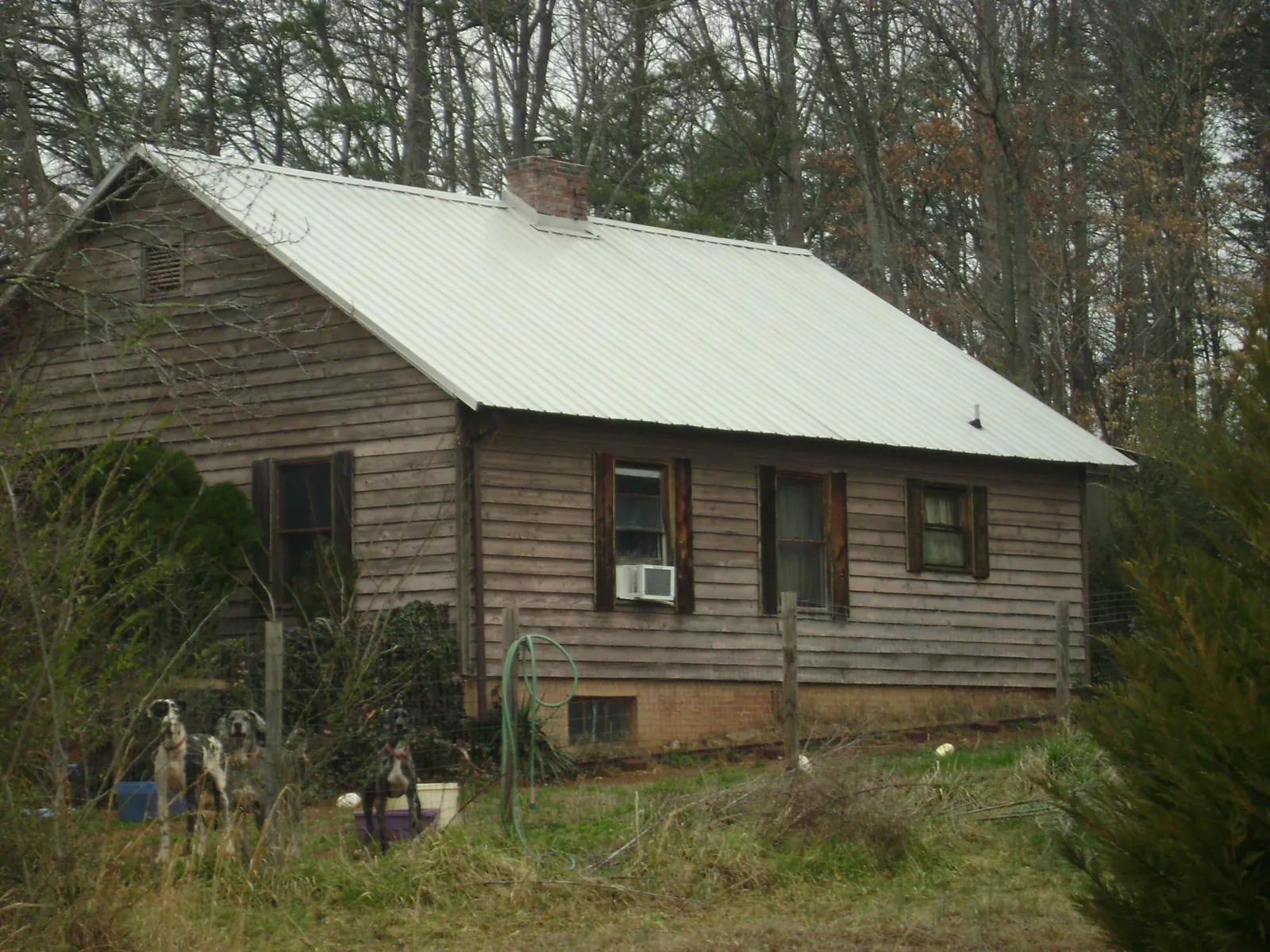 White metal roof on an old wood sided farmhouse, from a Metal Roof Installation job in Gassaway